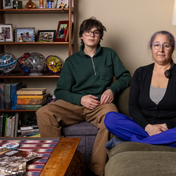 Mother and teen son sit in their living room
