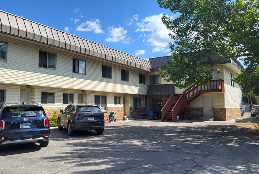 A two-story residential complex surrounding a parking area.