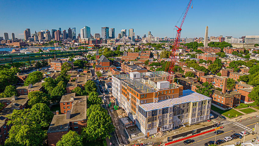 Housing development under construction with Boston skyline in the background.