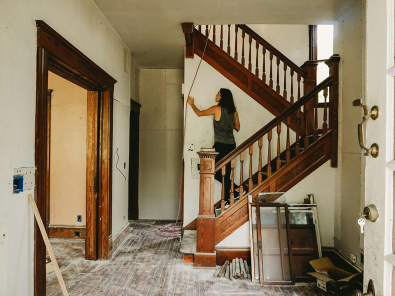 Woman on a staircase remodeling an old home.