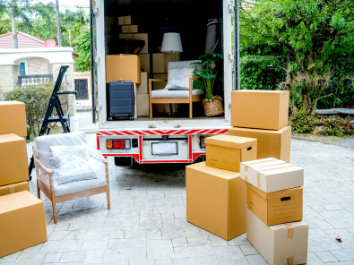 Moving truck and boxes in a driveway.