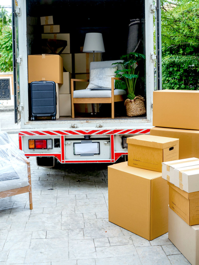 Moving truck and boxes in a driveway.