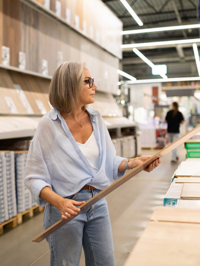 Woman browsing flooring at a home improvement store.