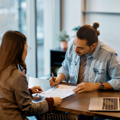 Man signing lease paperwork in realtor's office.