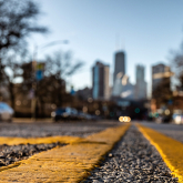 Street with city skyline in the background.