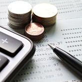 Stacks of coins next to calculator.