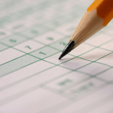 Pencil filling in a scorecard.