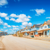 Street lined with homes under construction.