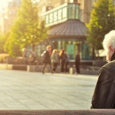 Older man sitting on a bench.