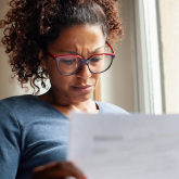 Woman looking at bills.