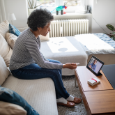 Woman using a tablet for a remote meeting.