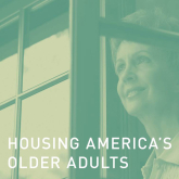 Older adult woman looking out window.