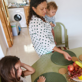 Mother and three children gathered at kitchen table.