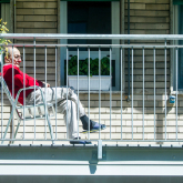 Older man sitting on a balcony