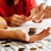 Coins being placed into a person's hands.
