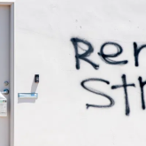 White wall with "rent strike" spray-painted.