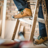Person climbing wooden step stool.