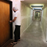 Man entering his apartment within larger building.