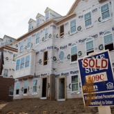 "Sold" sign in front of houses still under construction.