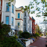 View of brick townhouses on a residential street.