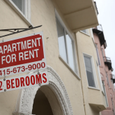 Building with "apartment for rent" sign.