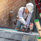 Roofer working on partially finished roof.