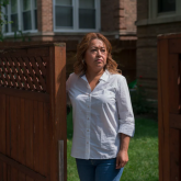 Woman standing at the opening of a fence