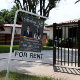 For-rent sign in front of small home.
