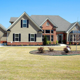 Large home with for-sale sign.
