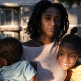 Woman with two children in front of home.
