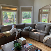 Man lounging on couch inside spacious home.