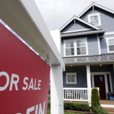 House with for-sale sign in front.