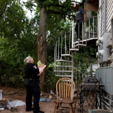Officer serving eviction order to renter.