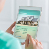Person looking at housing ad on tablet.