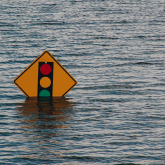 Street sign submerged in flood water.