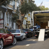 Moving truck parked on steep residential street.
