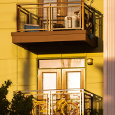 Apartment building with bike on balcony.