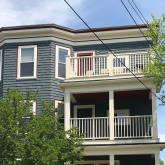 View of blue triple decker house facade.