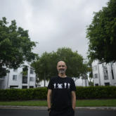 Man standing in front of apartment complex.