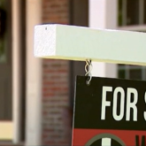 View of for-sale sign in front of home.