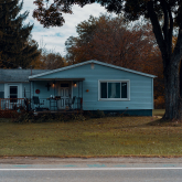 Small ranch house by roadside.