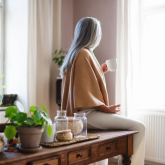 Older woman in her house looking out the window