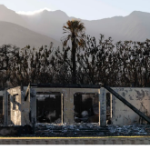 View of burnt wall in front of mountains.