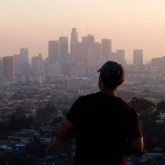 Person staring at smoggy city skyline.