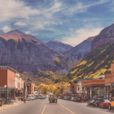 View of small town's main street, with mountains in background.
