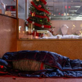 Person in a sleeping on the floor in a sleeping bag 