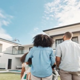 Family looking at a home from the front garden