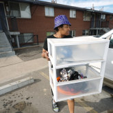 Man carrying portable shelf in a parking lot