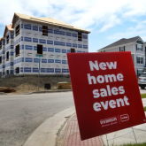 For sale sign infront of houses under construction