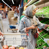 Couple shopping for food and checking costs